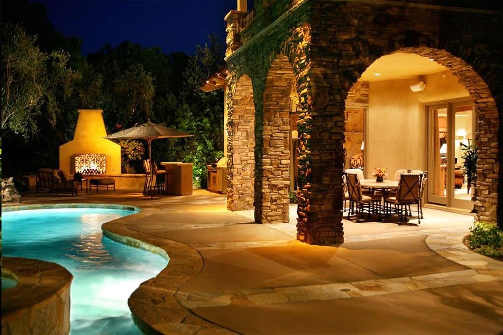 Modern backyard patio with warm outdoor lighting at dusk