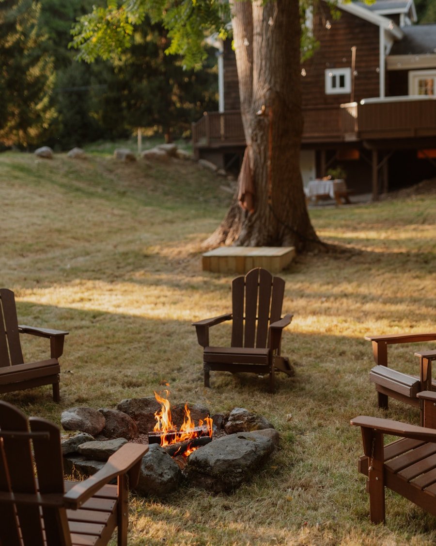 Adirondack chairs around a lit backyard fire pit at dusk